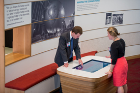 A man and woman use an interactive display in the Emerging Issues Common.