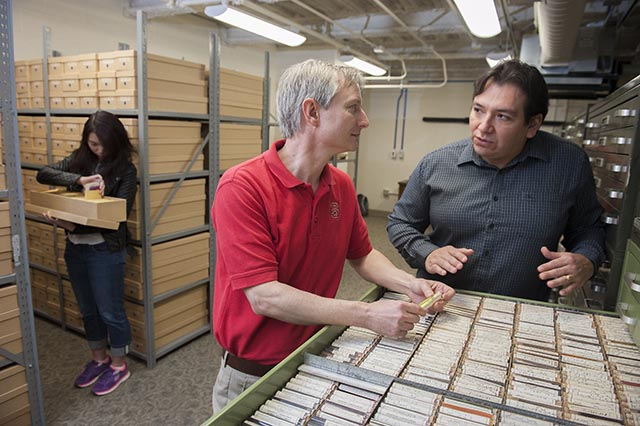 Textile chemist David Hinks (left), director of the emerging Forensic Sciences Institute, and analytical chemist Nelson Vinueza (right) inspect samples from the Max A. Weaver Dye Library.