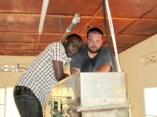 NC State junior Tyson Huffman (right) and a team member repair equipment at a facility producing sanitary pads in Rwanda.
