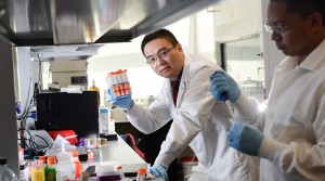 Dr. Zhen Gu of NC State holds up a red solution from his "nanodaisies" cancer research.