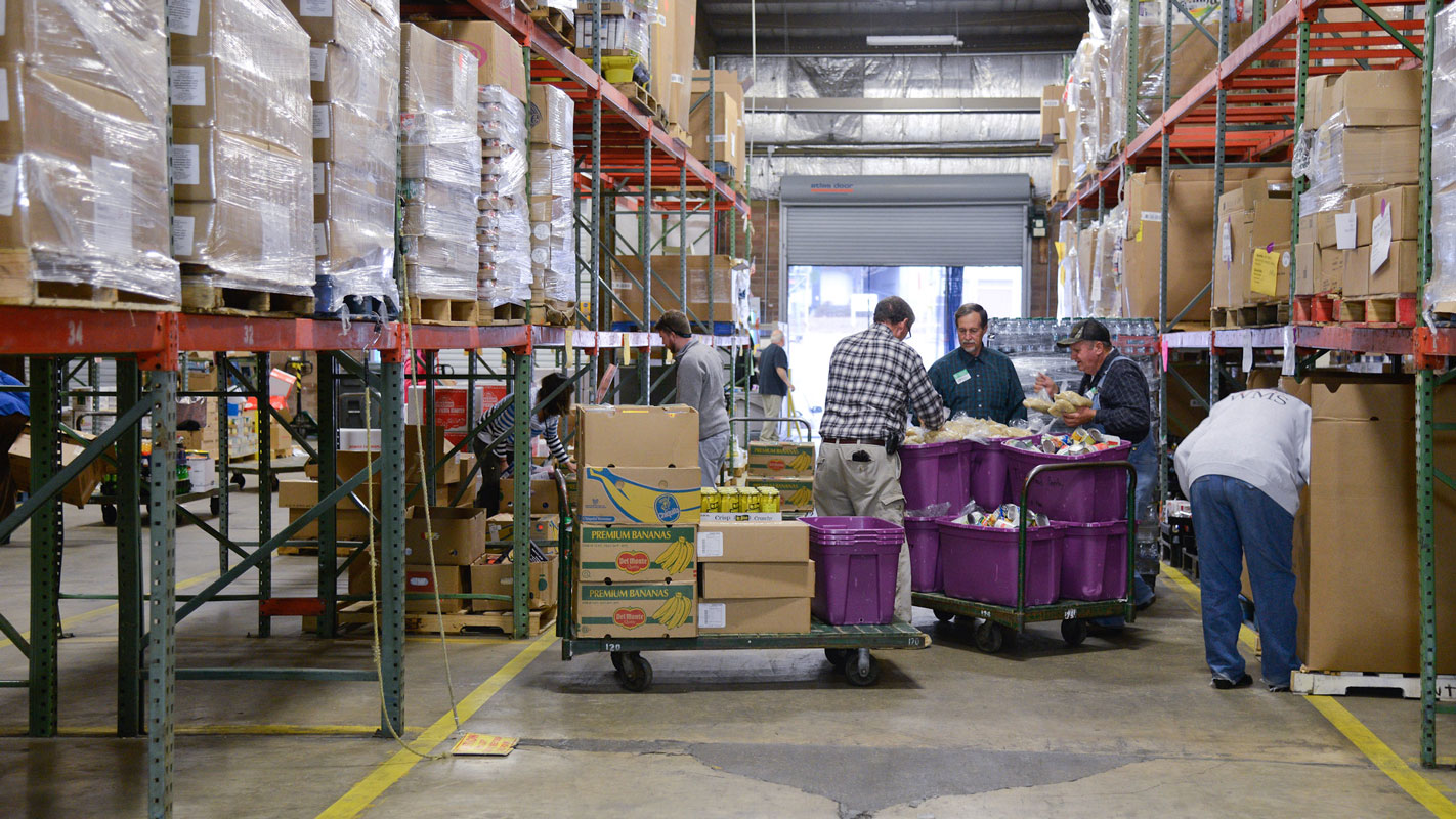 Buyers at the Food Bank of Central and Eastern North Carolina sort food in an aisle of the Raleigh branch.