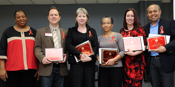 Five award winners with plaques.