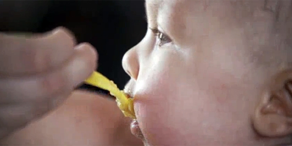 A baby eating baby food.