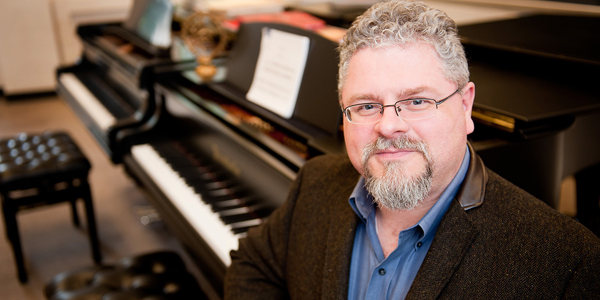 J. Mark Scearce, professor of art and design, sits at a piano.