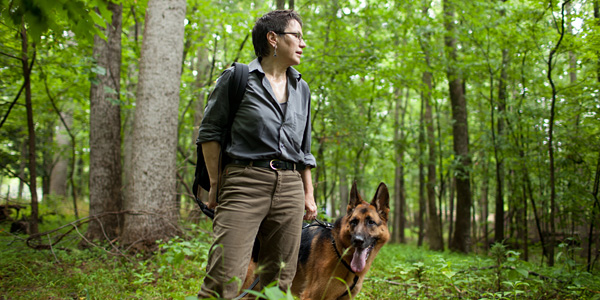 woman standing in woods with dog