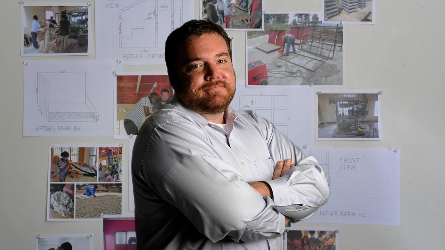 NC State student Tyson Huffman stands in front of a board showing construction plans.