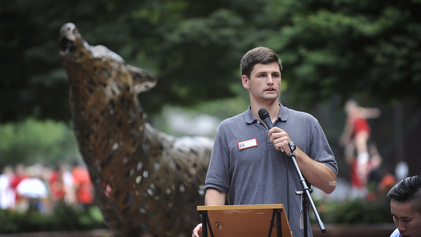 Rusty Mau addressing campus crowd in Wolf Plaza.