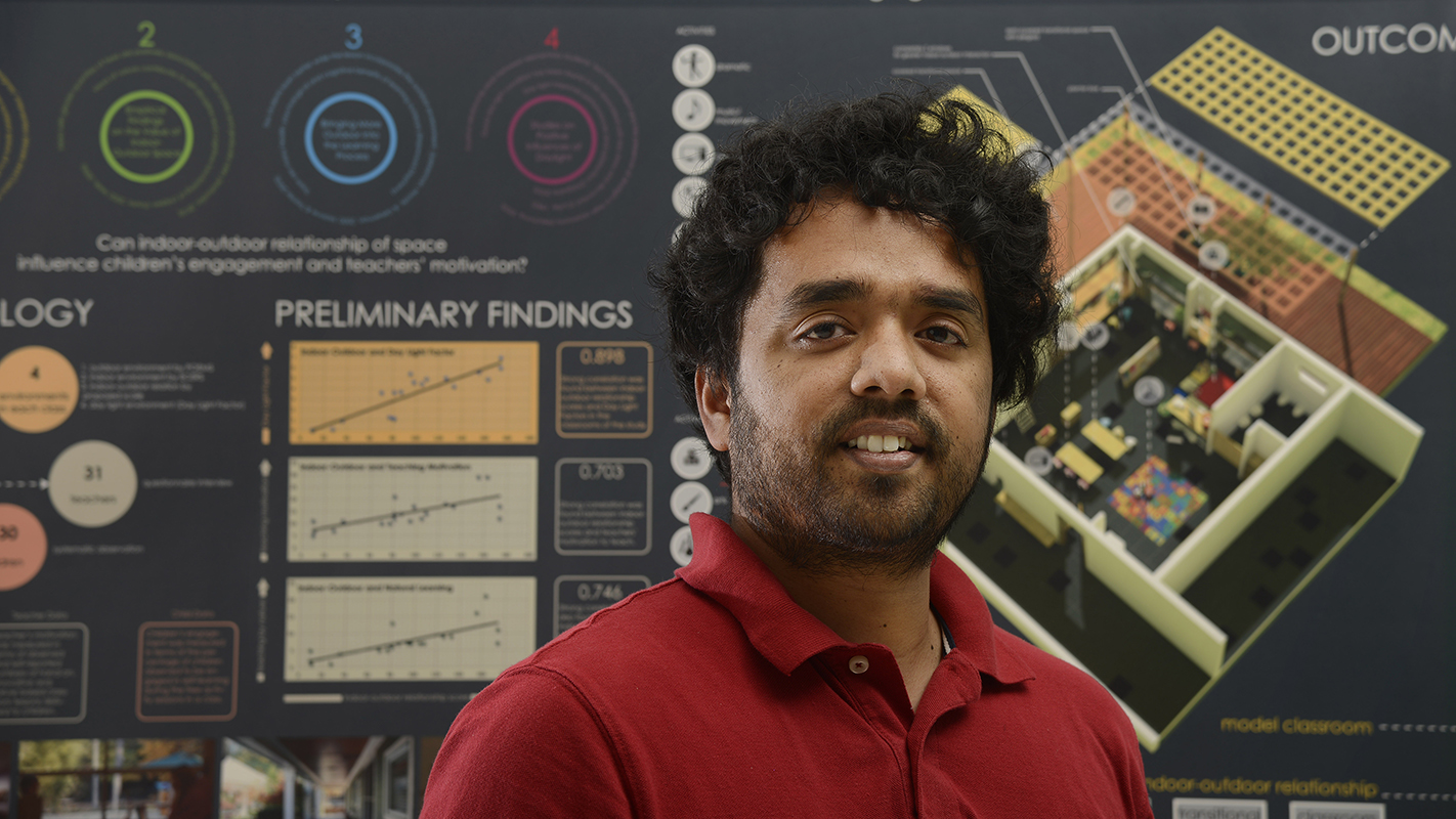 Muntazar Monsur in front of his research poster.