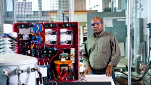 Hulgize Kassa, lab manager at NC State's FREEDM Systems Center, stands next to a transformer.