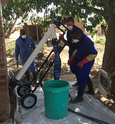 Rogers, (in rear, holding the equipment) field-tested the Excrevator with collaborators in Malawi. Photo courtesy of Tate Rogers.