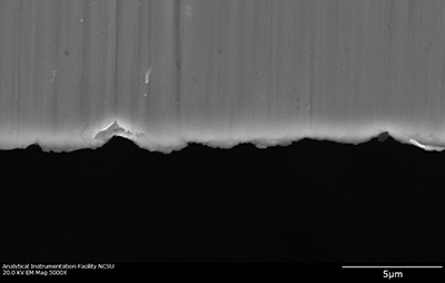 The micrometer-scale fissures on the edge of a surgical blade act as a "microcomb" to align carbon nanotubes. Image credit: Yuntian Zhu. Click to enlarge.