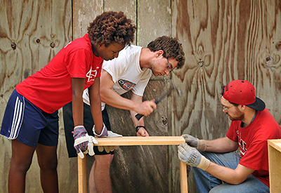 Students spend spring break on a service-learning trip to Belize. Amanda McKnight (left) and Darren Lipman (right) hold boards in place as Joey Brown hammers.