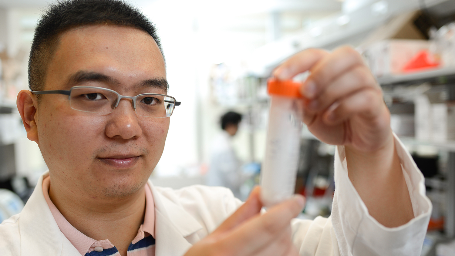 Zhen Gu holds up a solution in his lab on NC State's Centennial Campus.