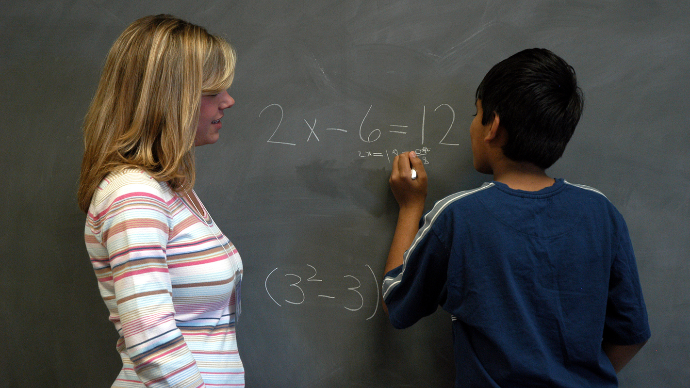 Teacher with student at blackboard