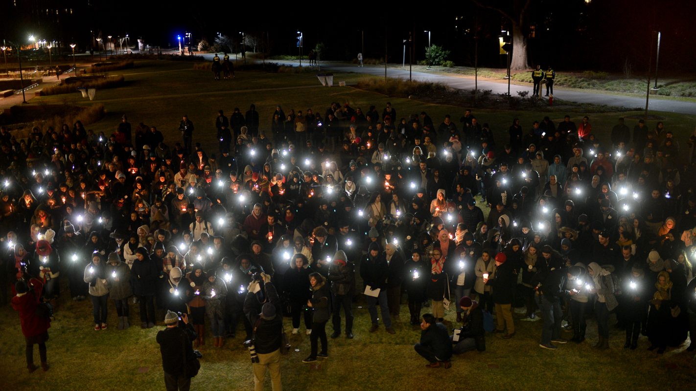 Smartphone lights take the place of candles in the brisk wind during the vigil.