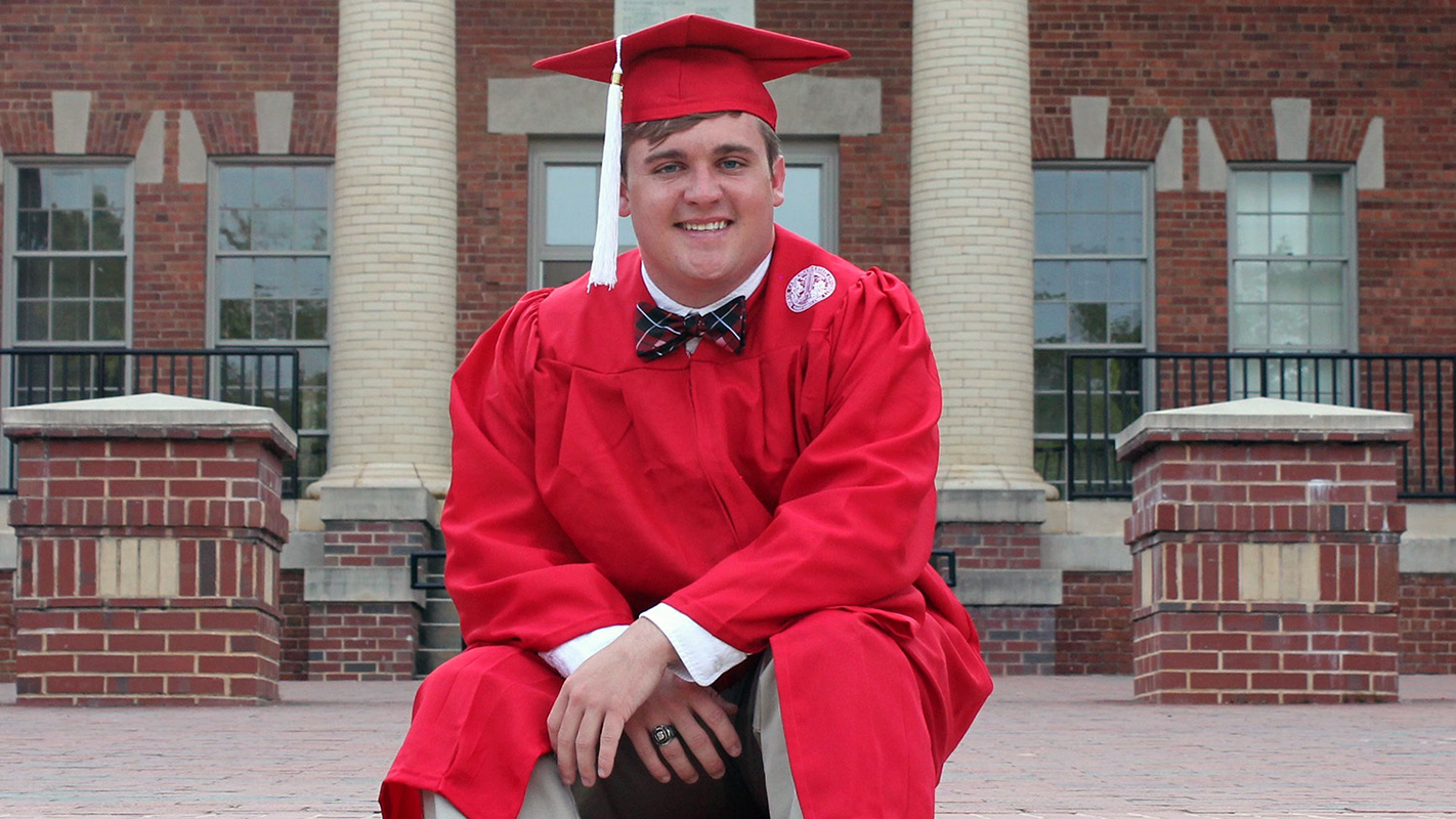 A portrait of Colin White of NC State's College of Natural Resources in his graduation robes.