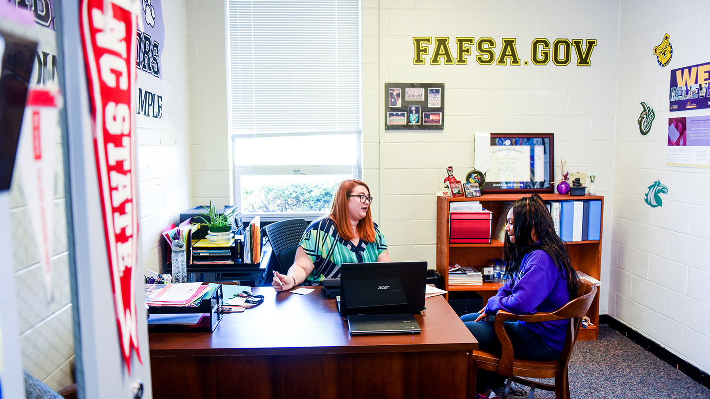 Dani Lechner advises a student in her office at South Creek High School in Martin County.