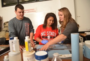 College of Textiles seniors Jamie McLain (left), Desirae Scruggs and Shannon Tart (right) work on the next generation of Gryppers.