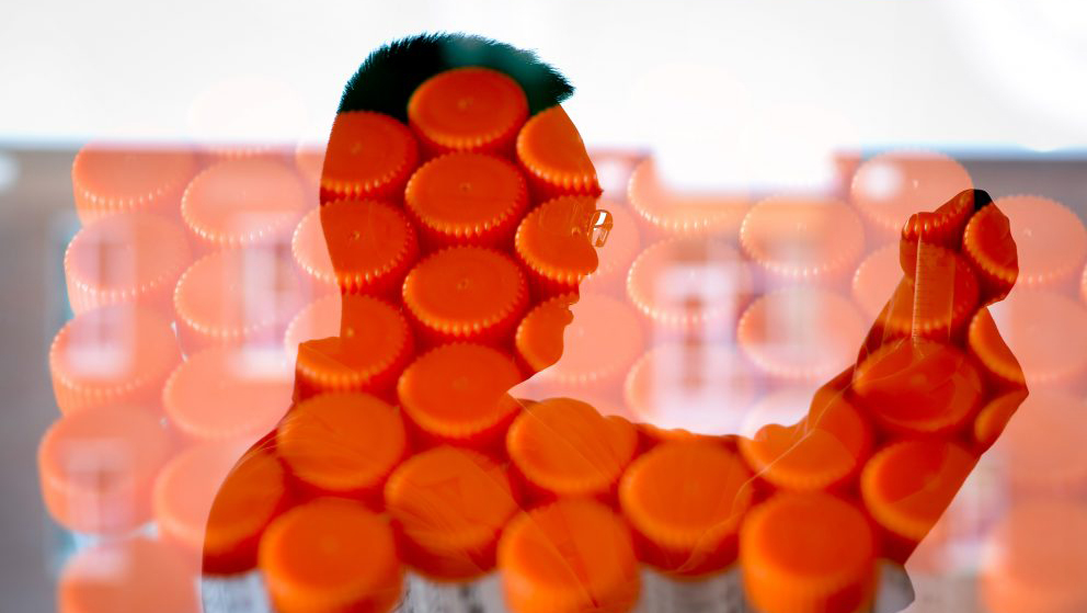 Orange test tubes superimposed over the profile of NC State researcher Zhen Gu.