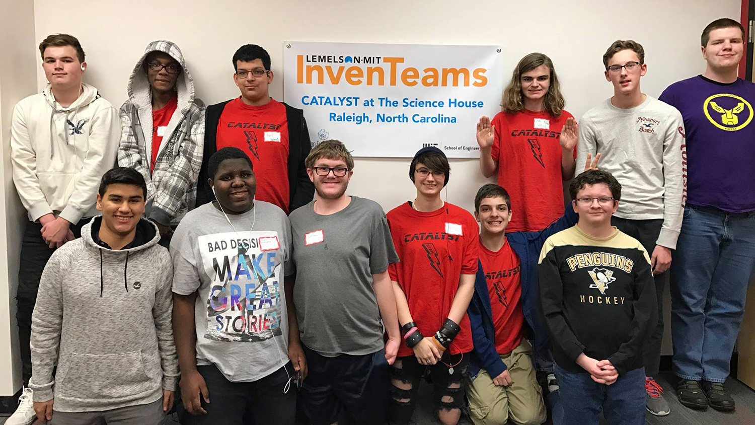 A group shot of the Catalyst InvenTeam in front of the banner bearing their name.