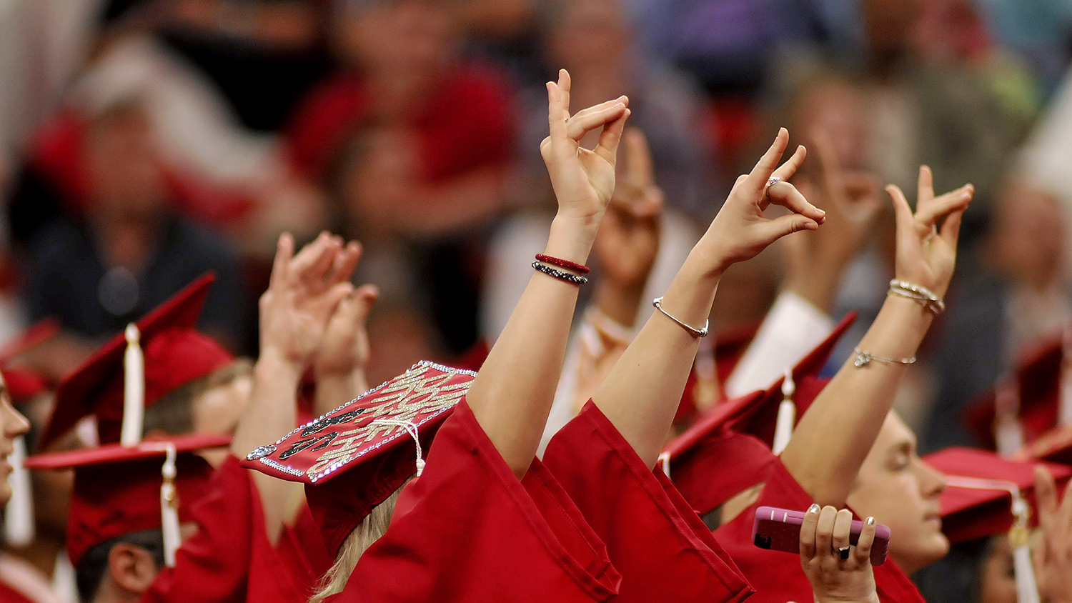 Newly minted NC State graduates throw up their wolf signs at Spring Commencement 2016.