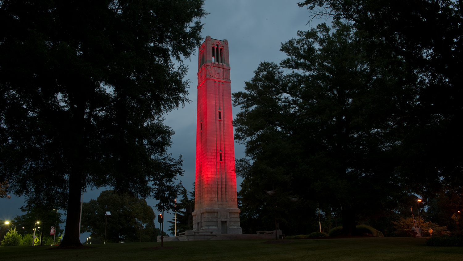 NC State Belltower lit from below with red lighting.