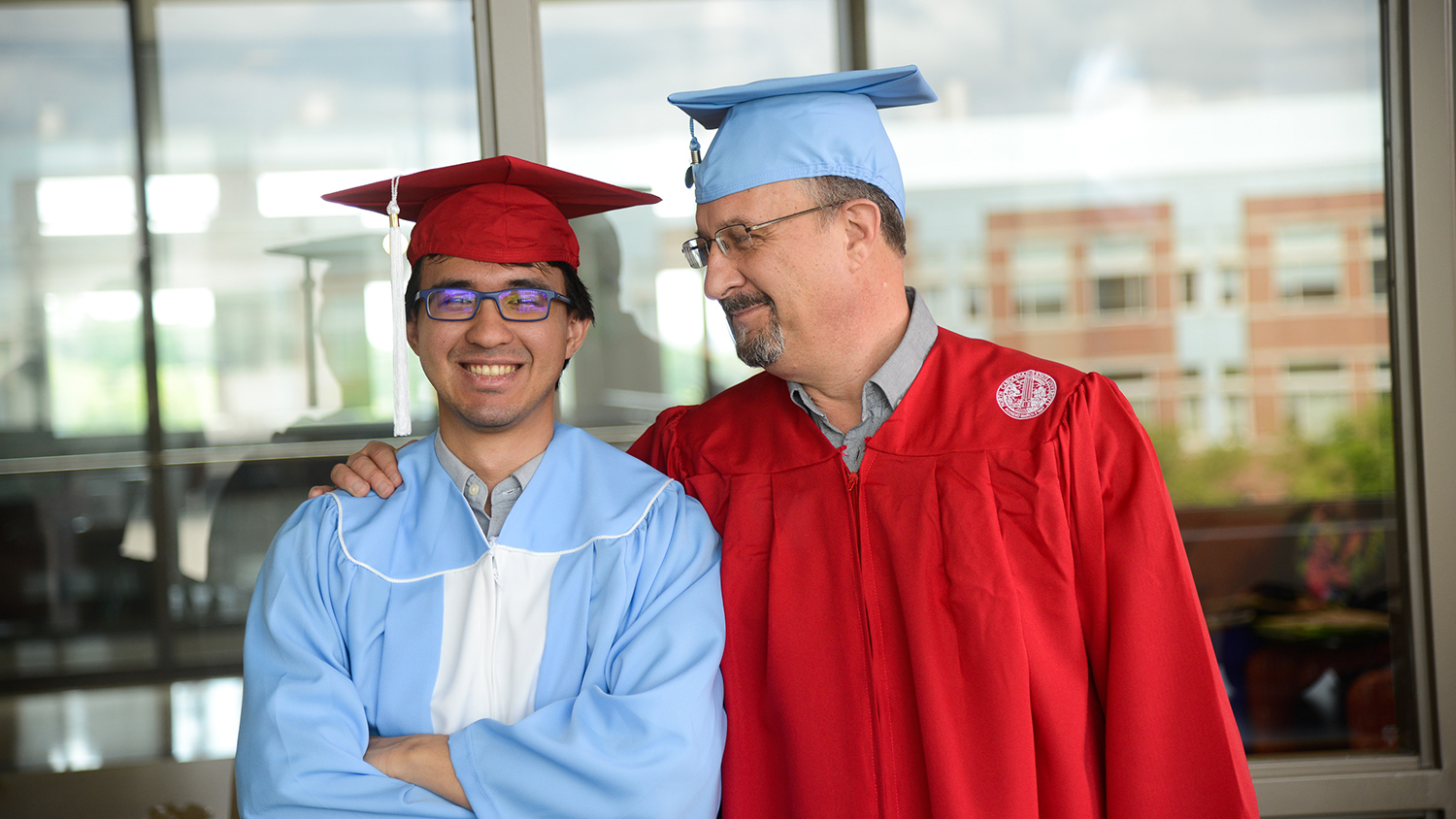 Timothy and David Calhoun smile in cap and gown