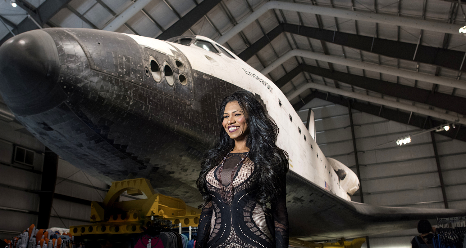 Rocket scientist Olympia LePoint stands in front of a space shuttle in a NASA hangar.