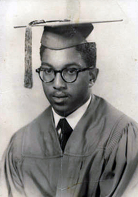 Graduation photo of Holmes in cap and gown.