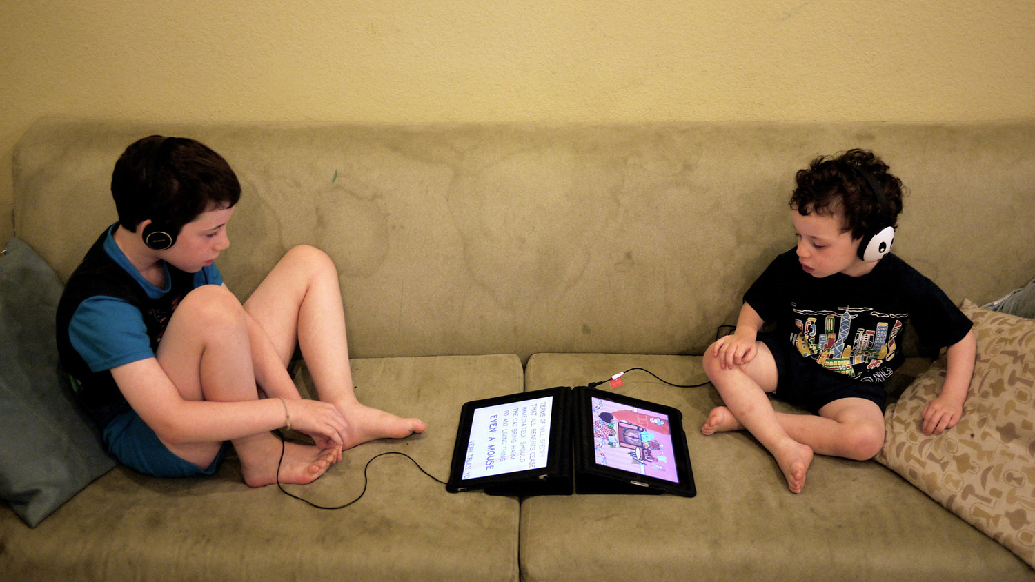 children on sofa with devices