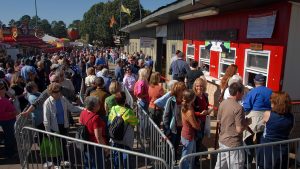 A long line of people wait for their turn at the Howling Cow ice cream order window 