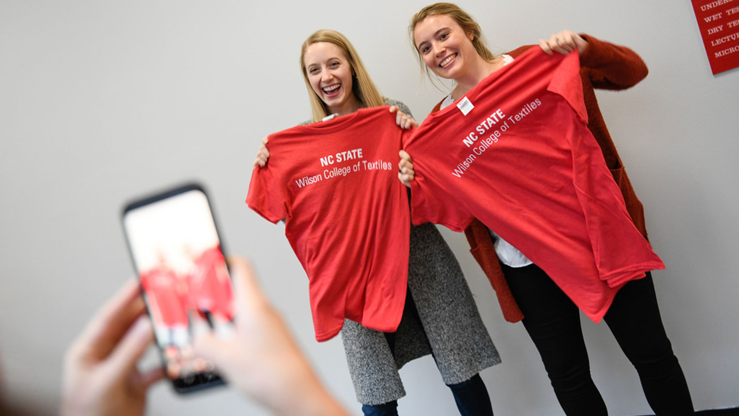 Students holding up t-shirts