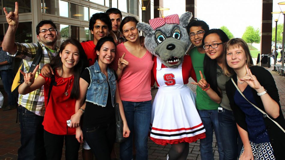 International students pose for a group shot with the mascot Mrs. Wuf