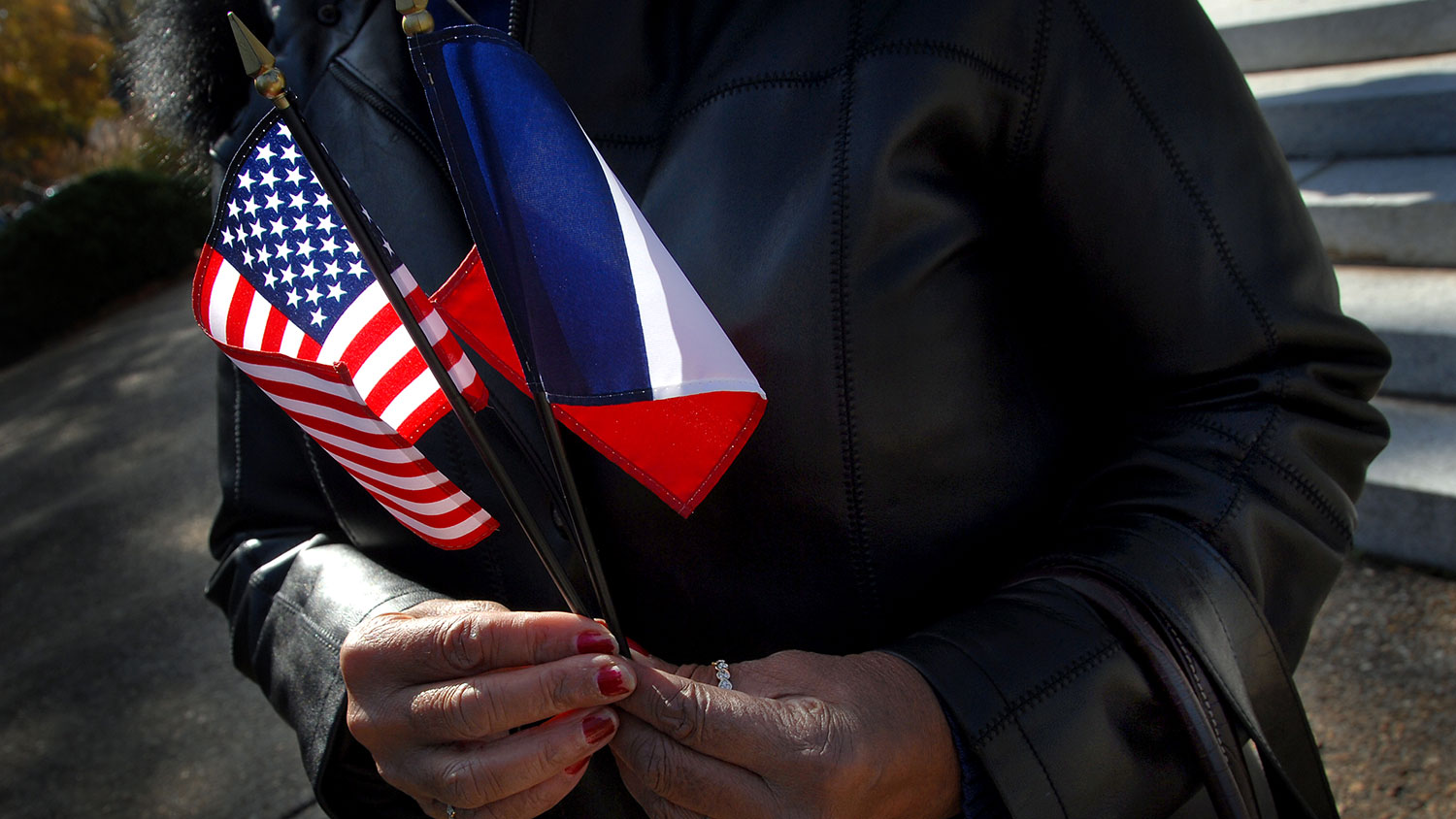 Hands holding American and French flags on Veterans Day