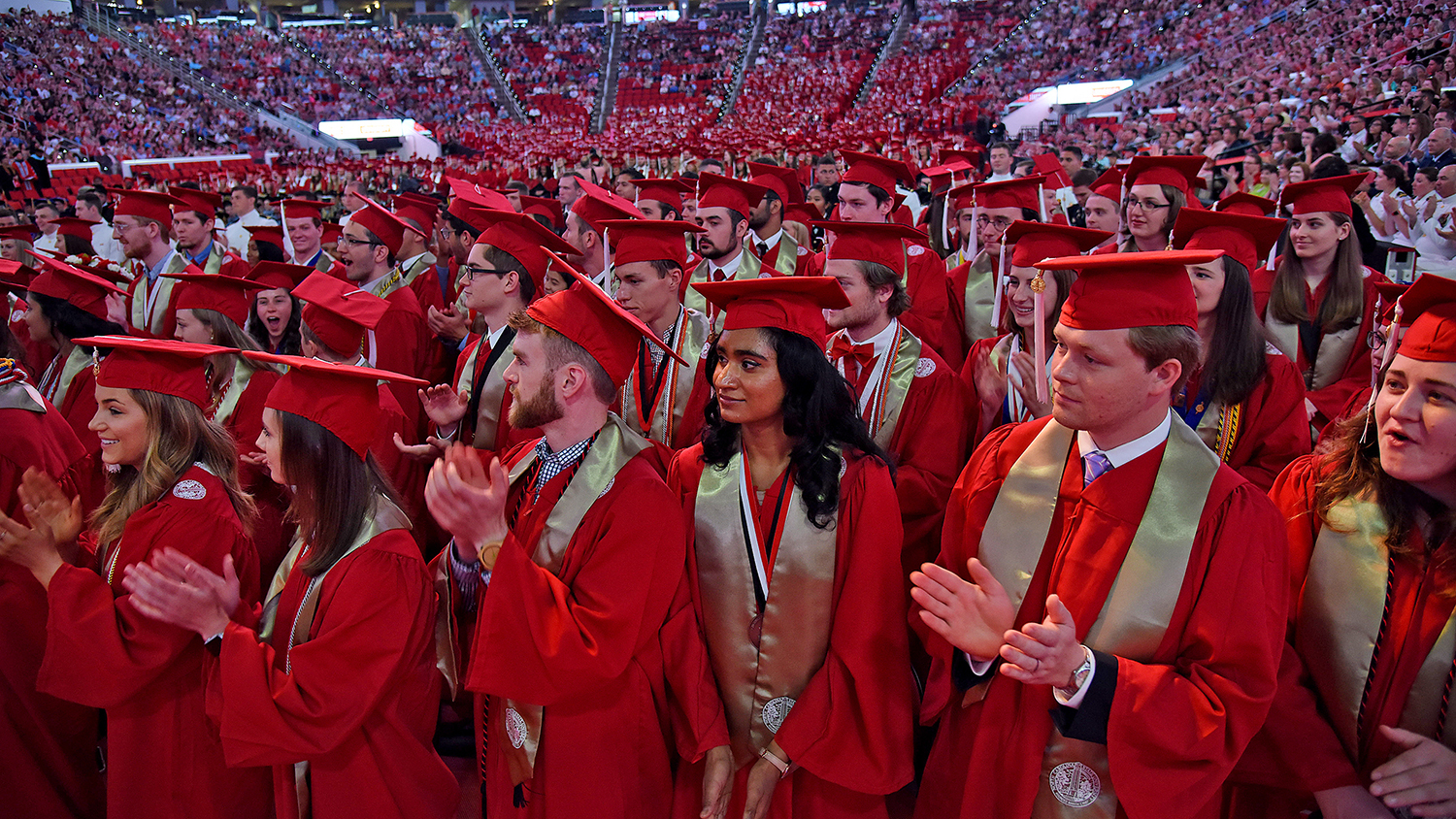 Graduates applaud their official conferment of their degrees.