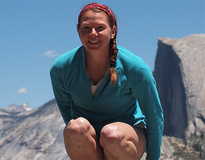 woman crouching on boulder