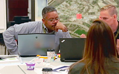 Kofi Boone at a table talking with colleagues.