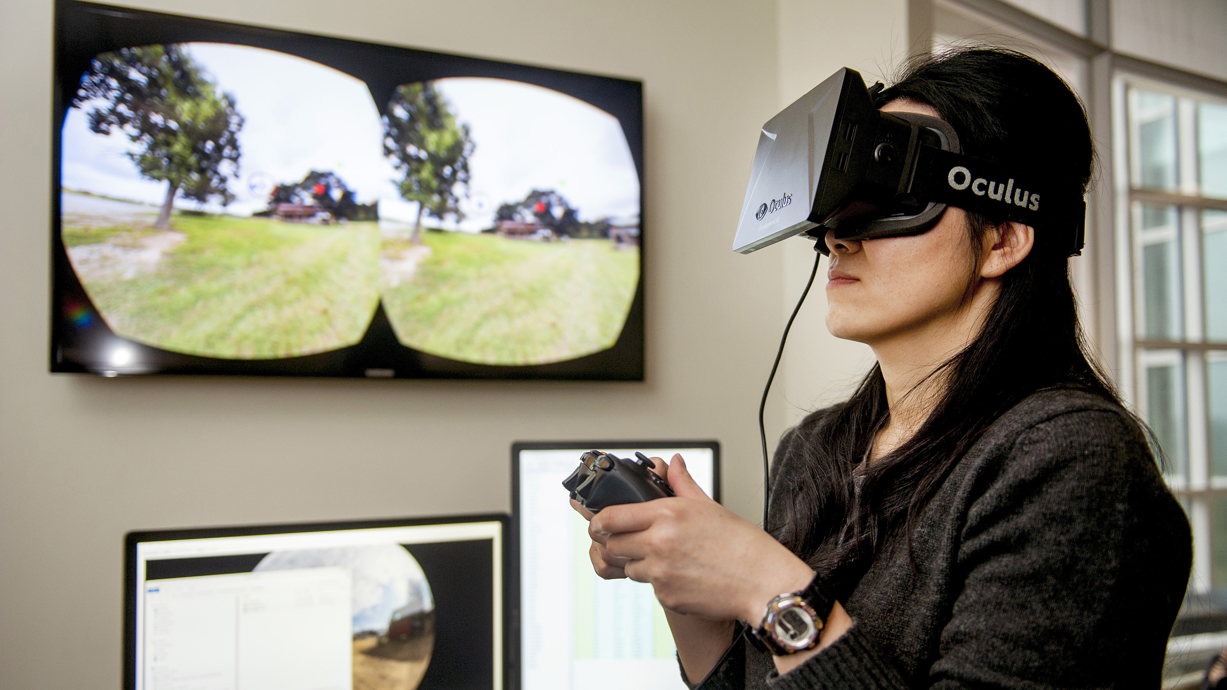 A student looks through virtual reality goggles and uses a controller