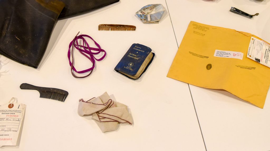 A pocket New Testament, combs, a handkerchief and and envelope discarded at the U.S.-Mexico border, on display in the Gregg Museum.