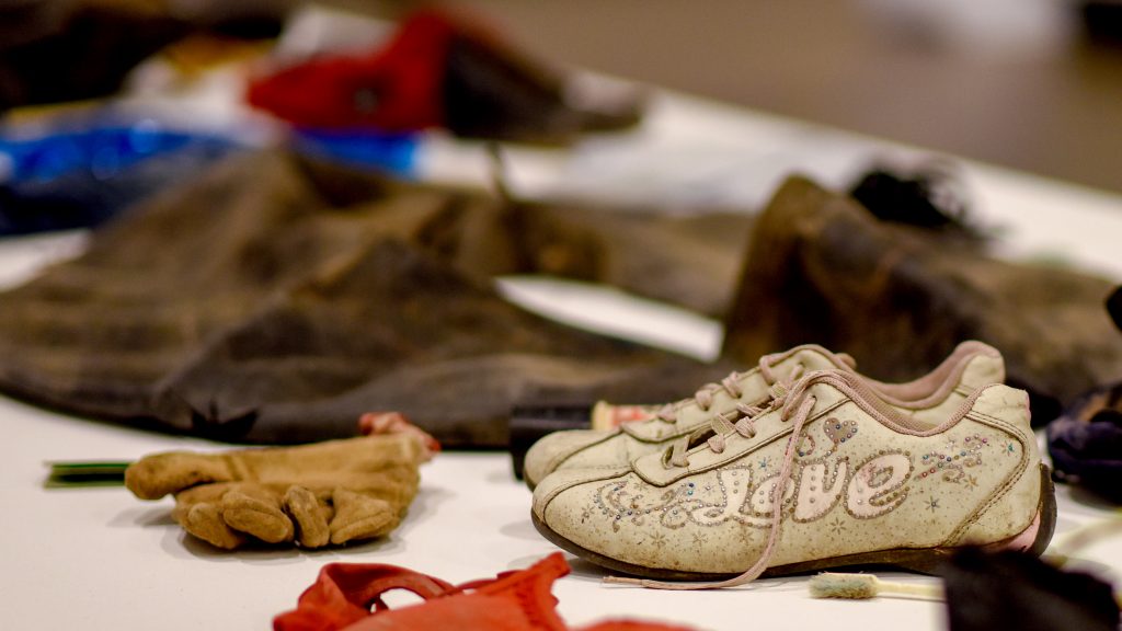 Sneakers, a glove and a deflated inner tube on display in the Gregg Museum.