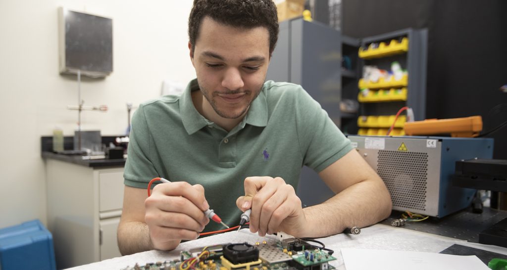Ziad Ali working on a circuit board in the lab.