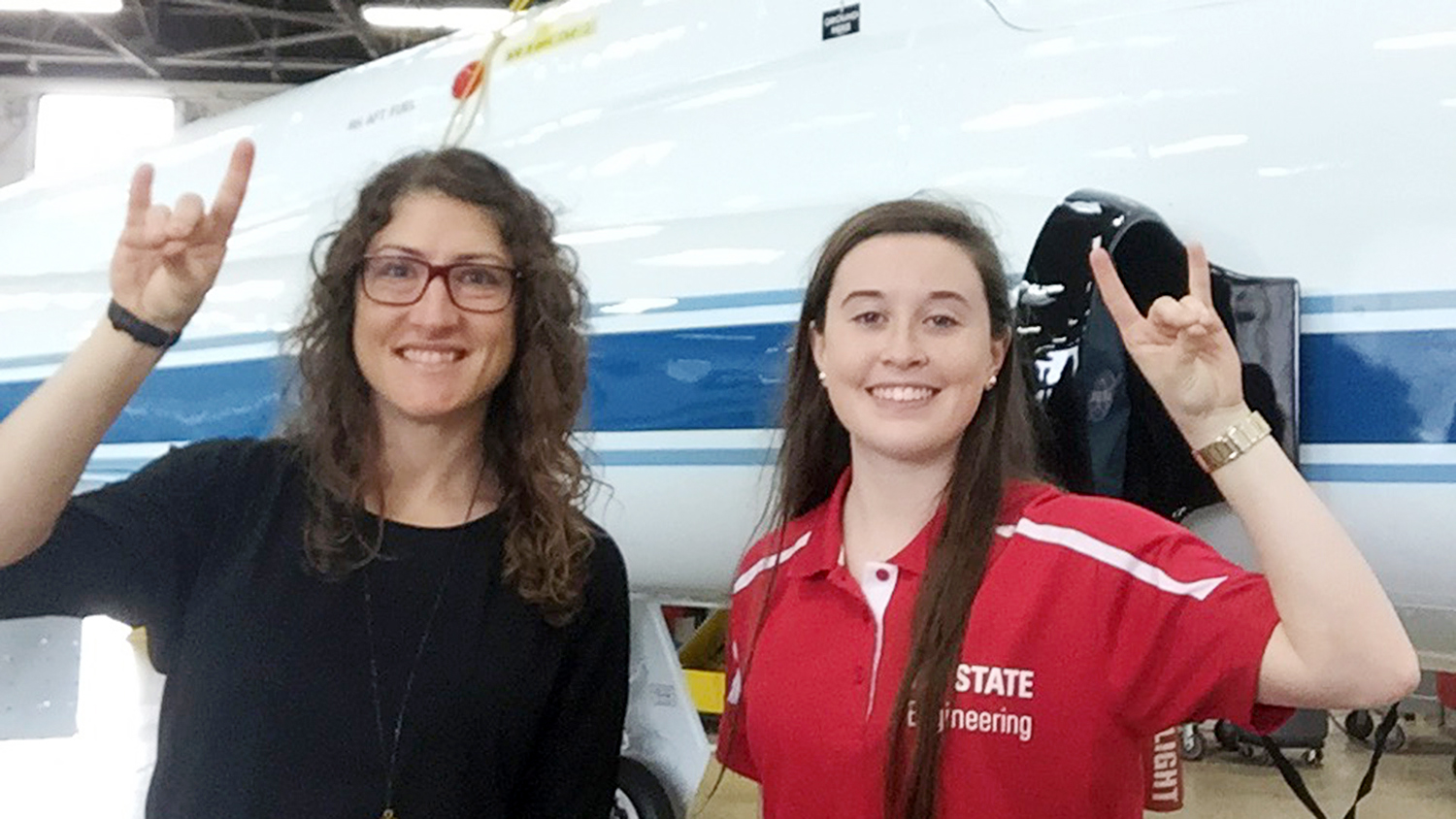 Christina Koch and Madison Maloney in front of NASA shuttle.