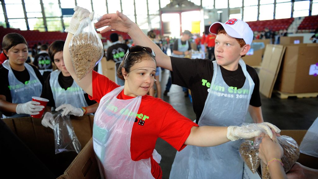Two young people volunteering in a food drive.