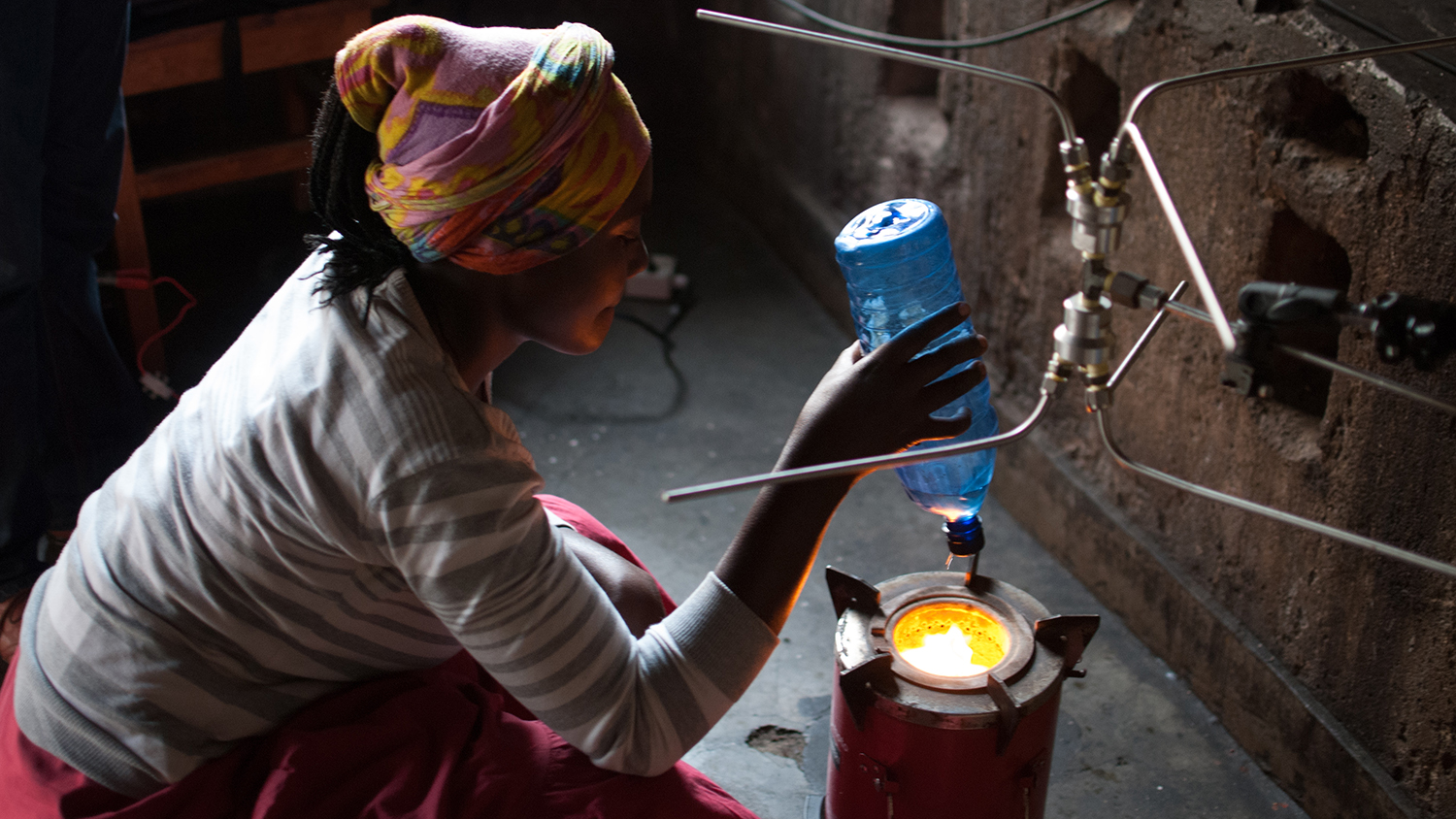 woman crouching by cookstove