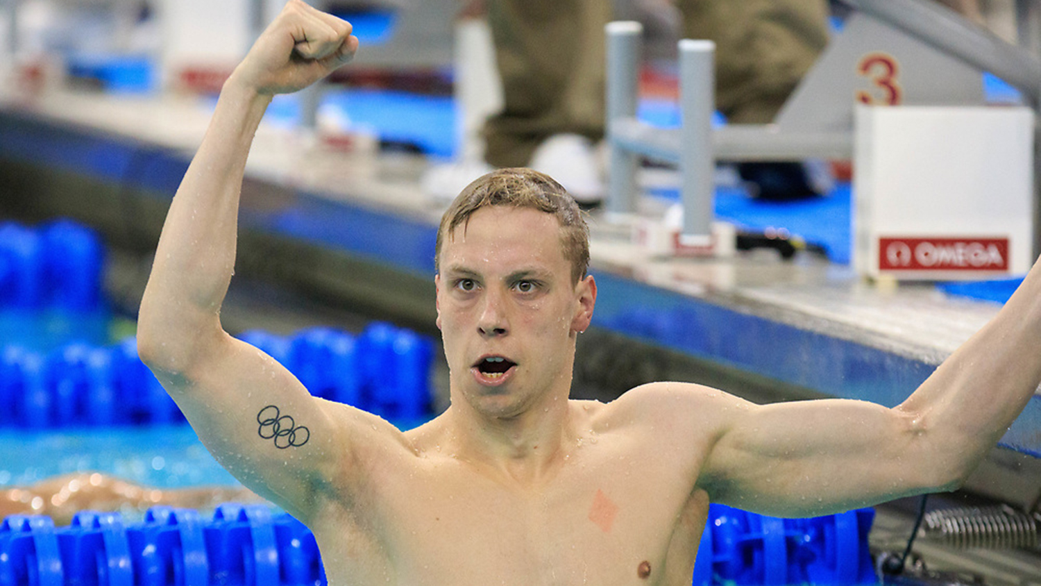 Anton Ipsen in the pool with his fist raised in a victory salute.