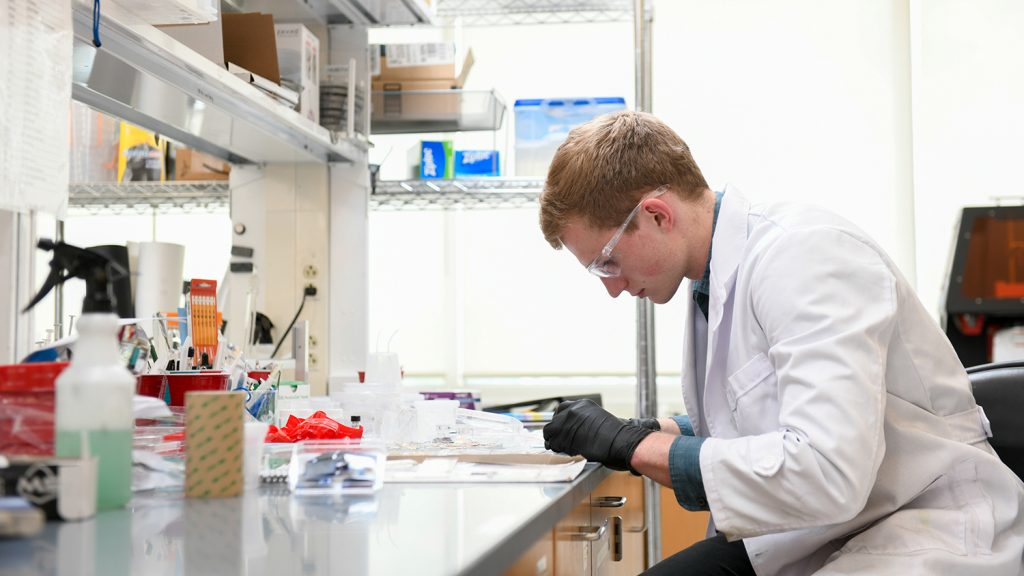 Baugh seen from the side, working at his lab bench.