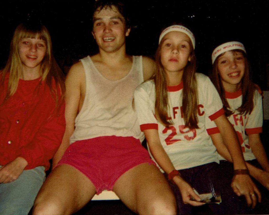 Basketball player posing with three girls.