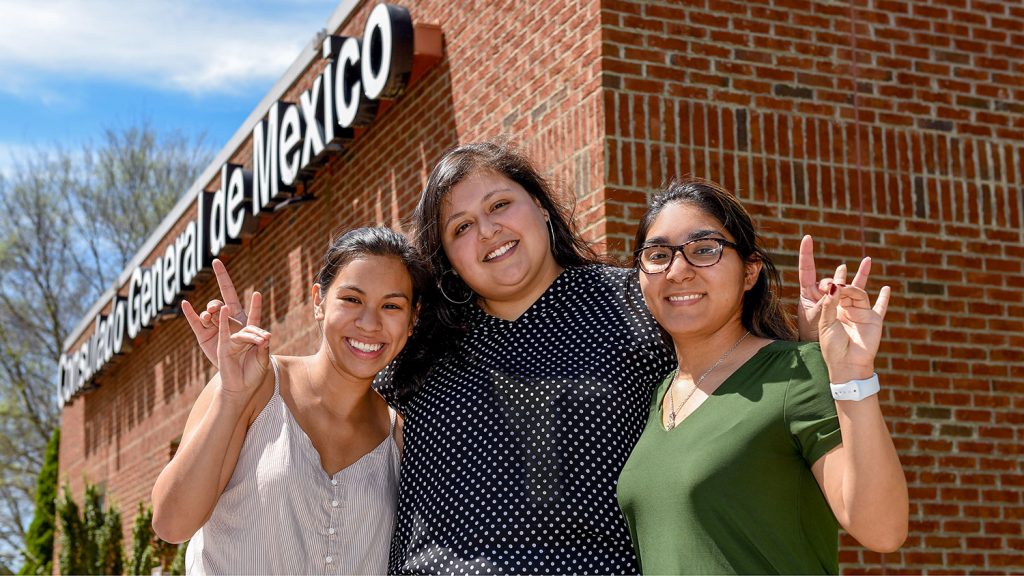 Three women standing in front of the Mexican Consulate of Raleigh