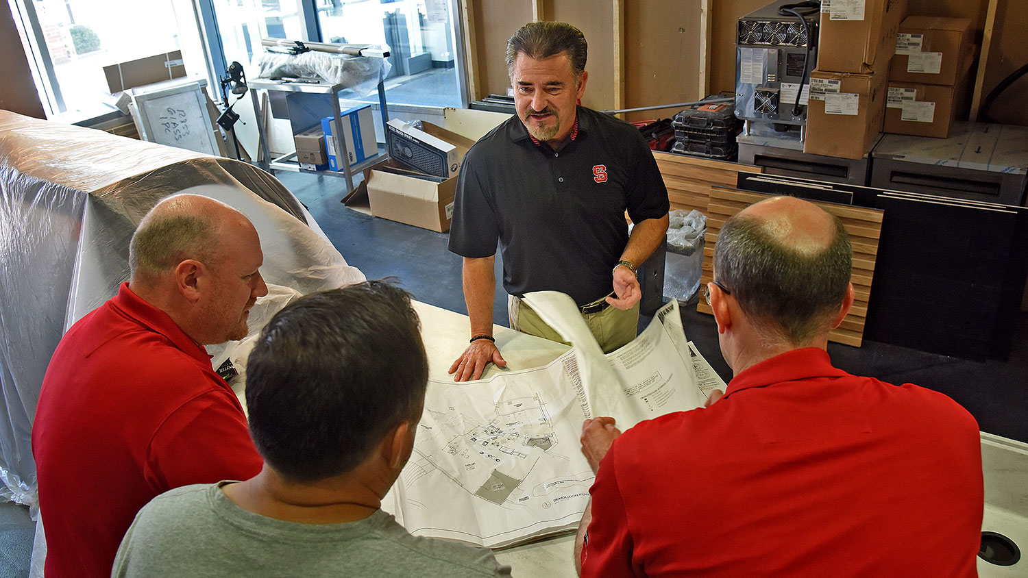 Group of men looking at architectural drawings