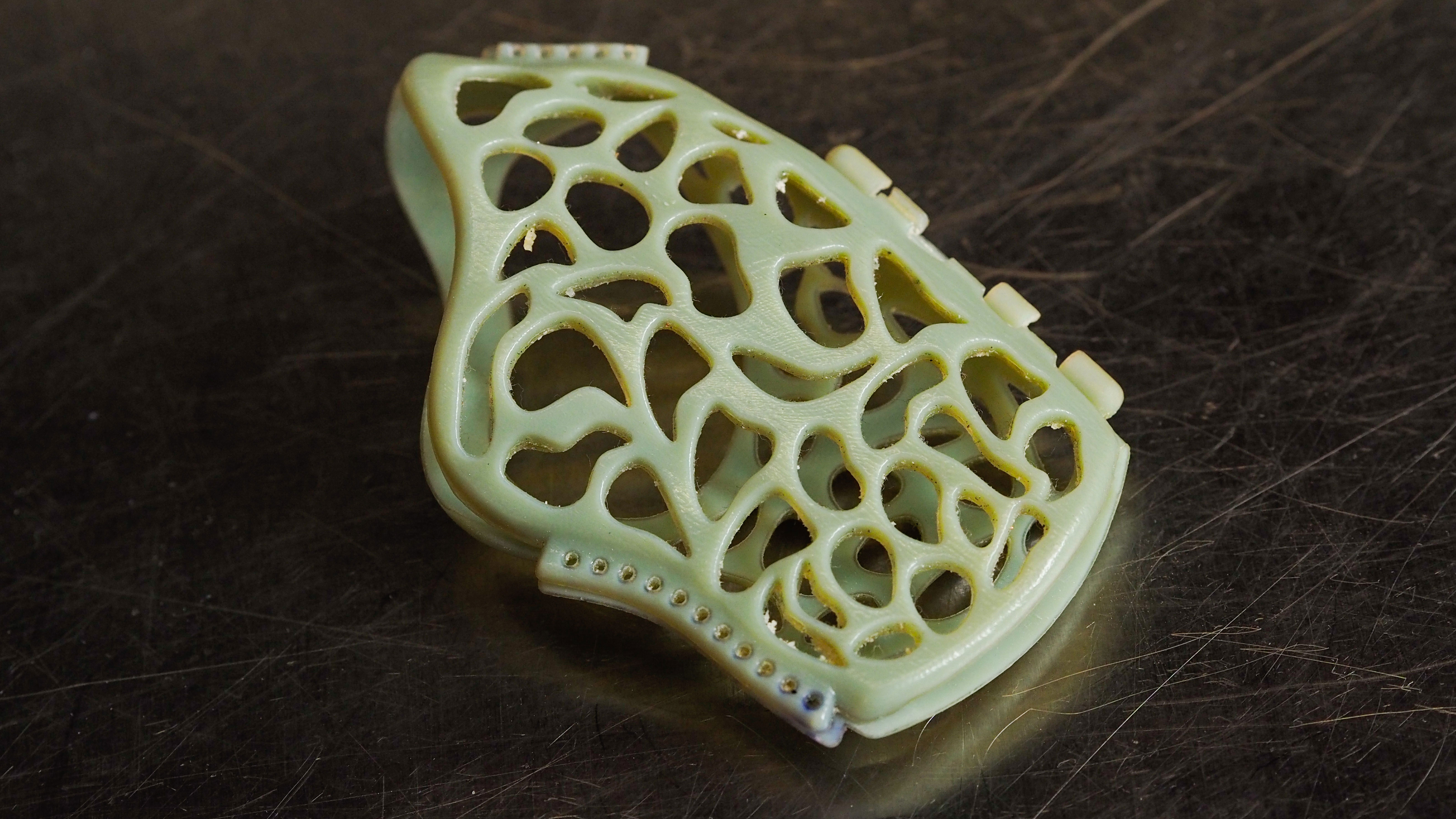 A green, 3D-printed splint created for a sea turtle with an injured flipper